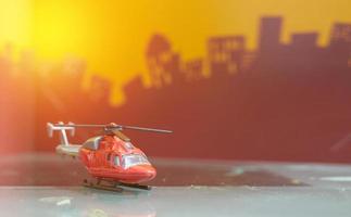 Red toy single  blade helicopter on blur city background photo