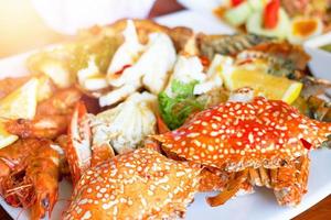 Sea food on big plate include shrimps ,lemon,squid and crab shell photo