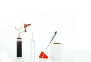 Tuning fork , Otoscope,tissue paper roll and hammer jerk on white floor ,top view with copy space photo