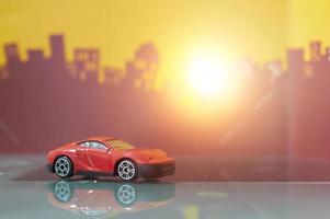 coche sedán rojo juguete enfoque selectivo en el fondo de la ciudad borrosa foto