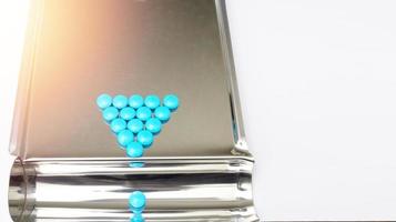 triangle arrangement blue coated tablet on tray in drugstore business and healthcare concept with copy space photo