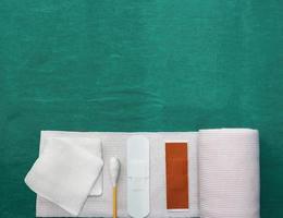 tools includes plaster,swab,blood gauze and roll gauze on green surgical dress for clean wound photo