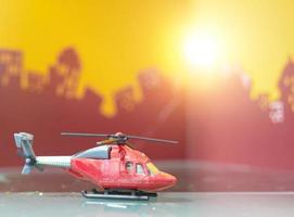 Red toy helicopter on blur city background photo