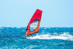 windsurfista diviértete montando las olas durante un día soleado de verano foto