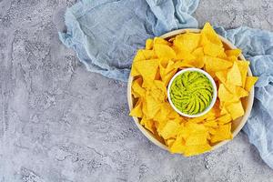 Mexican nachos with cheese. Corn chips with guacamole, salsa and tomato ketchup. photo