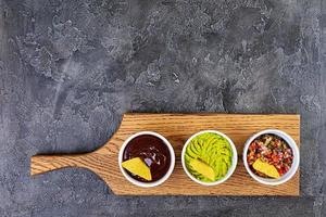 Mexican nachos with cheese. Corn chips with guacamole, salsa and tomato ketchup. photo