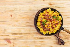 Mexican nachos with cheese. Corn chips with guacamole, salsa and tomato ketchup. photo