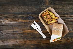 Delicious shawarma sandwich with chicken and potato on wooden background photo