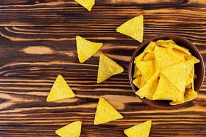 Mexican nachos with cheese. Corn chips isolated on wooden background photo