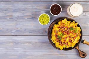 Mexican nachos with cheese. Corn chips with guacamole, salsa and tomato ketchup. photo