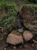 fotos de la eliminación de agua simple del agricultor, durante el día. hecho con materiales simples usando bambú. algunos usan una pipa.
