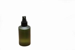 Green cosmetic bottle with label isolated on white background. Close up aroma spray bottle. Concept of organic cruelty free. Natural organic spa cosmetics concept. photo