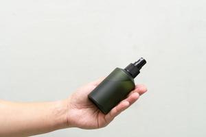 botella cosmética verde con etiqueta aislada sobre fondo blanco. cierre la botella de spray de aroma. concepto de libre de crueldad orgánica. concepto de cosmética de spa orgánico natural. foto