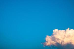 las nubes cumulus blancas reflejan la luz del sol de la tarde sobre un fondo azul, más que el espacio de una imagen, abstracto natural. foto