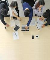 concepto de banner de trabajo empresarial vertical. el equipo corporativo asiático se reúne y usa una computadora portátil en el escritorio de la sala de juntas, copie el espacio. enfoque selectivo. foto