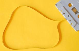 Top view photography of old plastic cassette with copy space magnetic tape on isolated yellow background. photo