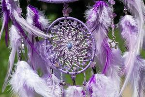 atrapasueños hecho a mano con hilos de plumas y cuerda de cuentas colgando foto