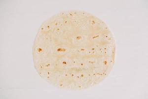 Thin pita bread on a white wooden table background photo