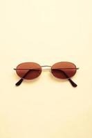 Brown sunglasses on bright cream white background. photo