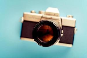 imagen borrosa de una cámara de película antigua de 35 mm. cámara de película sobre fondo azul en desenfoque. foto