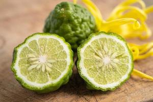 Fresh bergamot fruit with cut in half on wooden background. photo