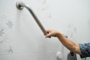 Asian senior or elderly old lady woman patient use toilet bathroom handle security in nursing hospital ward, healthy strong medical concept. photo