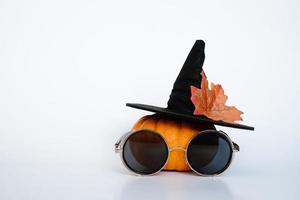 pequeña calabaza creativa con sombrero de bruja y gafas foto