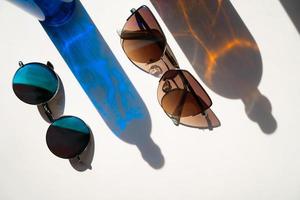 Blue and brown sunglasses with glass bottle reflections photo