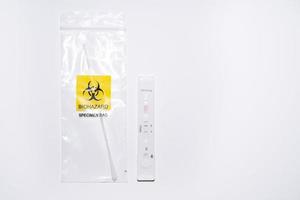 Positive covid self-test and swab in biohazard bag photo