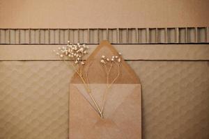 textured cardboard with recycled paper envelope and baby's breath Gypsophila photo
