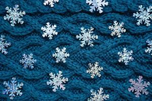 teal blue knit sweater background with silver snowflakes photo