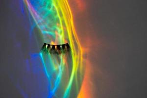 Fake eye lashes in a rainbow water reflection photo