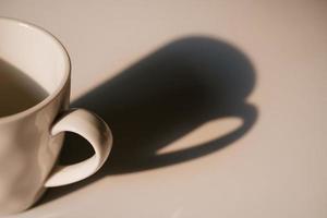 Coffee cup with long shadow side view photo