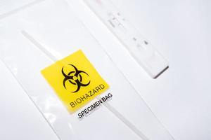 Positive covid self-test and swab in biohazard bag photo