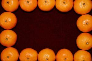 Ripe Clementine frame on red Background photo