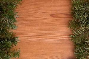 pine fir branch frame on light wood background photo