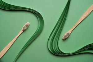 Bamboo toothbrushes on green background with quilling photo