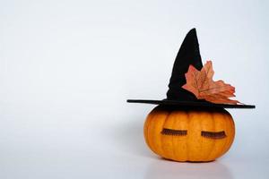Small pumpkin with witch hat autumn leaf and eyelashes photo
