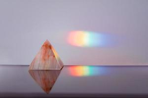 Agate pyramid with a rainbow streak background photo