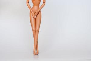 Nude doll covering pelvic area white background photo