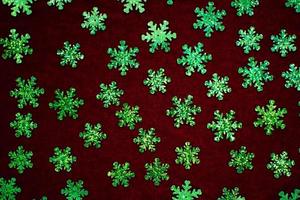 green glitter snowflake on red velvet photo