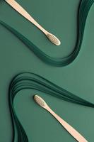 Bamboo toothbrushes on green background with quilling photo