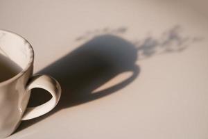 Coffee cup with long shadow and baby's breath side view photo