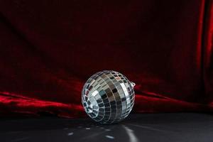 disco ball on black paper and red velvet background photo