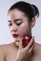 Asian woman with red apple in hand