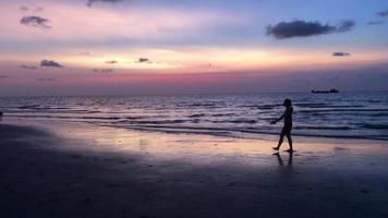 sagoma di donna che cammina sulla spiaggia al crepuscolo video