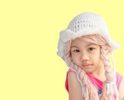 niña asiática, niño pequeño en edad preescolar con sombrero de punto coletas trenzas cabello mirando a la cámara. foto