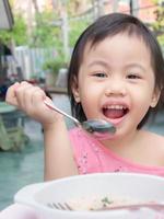 encantadora niña asiática de 2-3 años de edad, pequeña niña pequeña disfrutando de su desayuno. foto