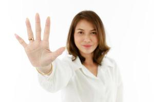 Portrait of Asian woman showing his five fingers for number 5 or prohibit, refuse manner. Selective focus on hand photo