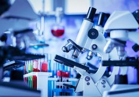 Microscope in and laboratory and test tube equipment in lab blue lights, science and experiment concept photo